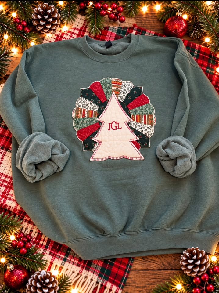 Sage green sweatshirt with a Dresden plate quilt circle in red, green, and cream fabrics topped by a cream Christmas tree monogrammed JGL in red